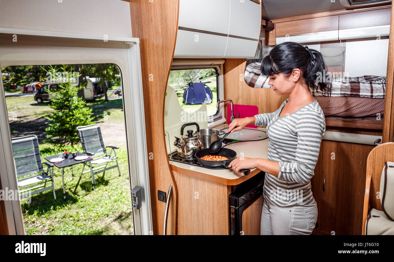 Donna cucinare in camper, camper interni. Vacanza per la famiglia in viaggio, viaggio vacanza in camper, caravan auto vacanza. Foto Stock