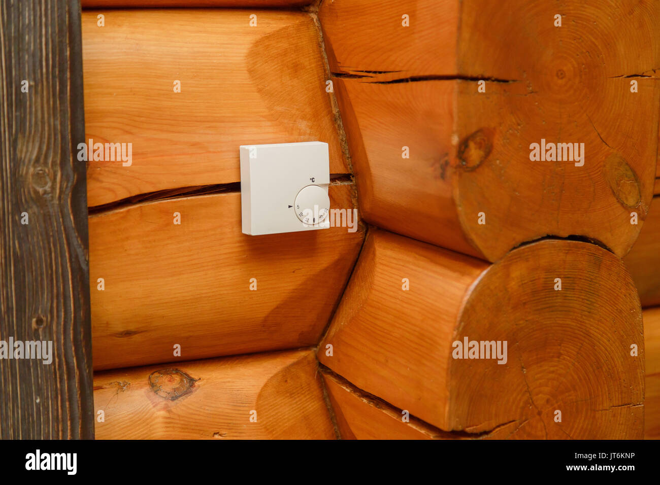 Temperatura ambiente centralina per il riscaldamento e il raffreddamento su una parete in una casa di legno. Foto Stock