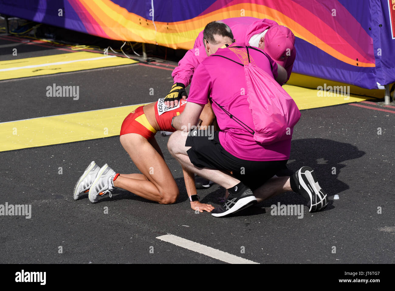 Marta Esteban spagnola è stata assistita dopo aver terminato la gara di maratona dei Campionati del mondo IAAF 2017 a Londra, Regno Unito Foto Stock
