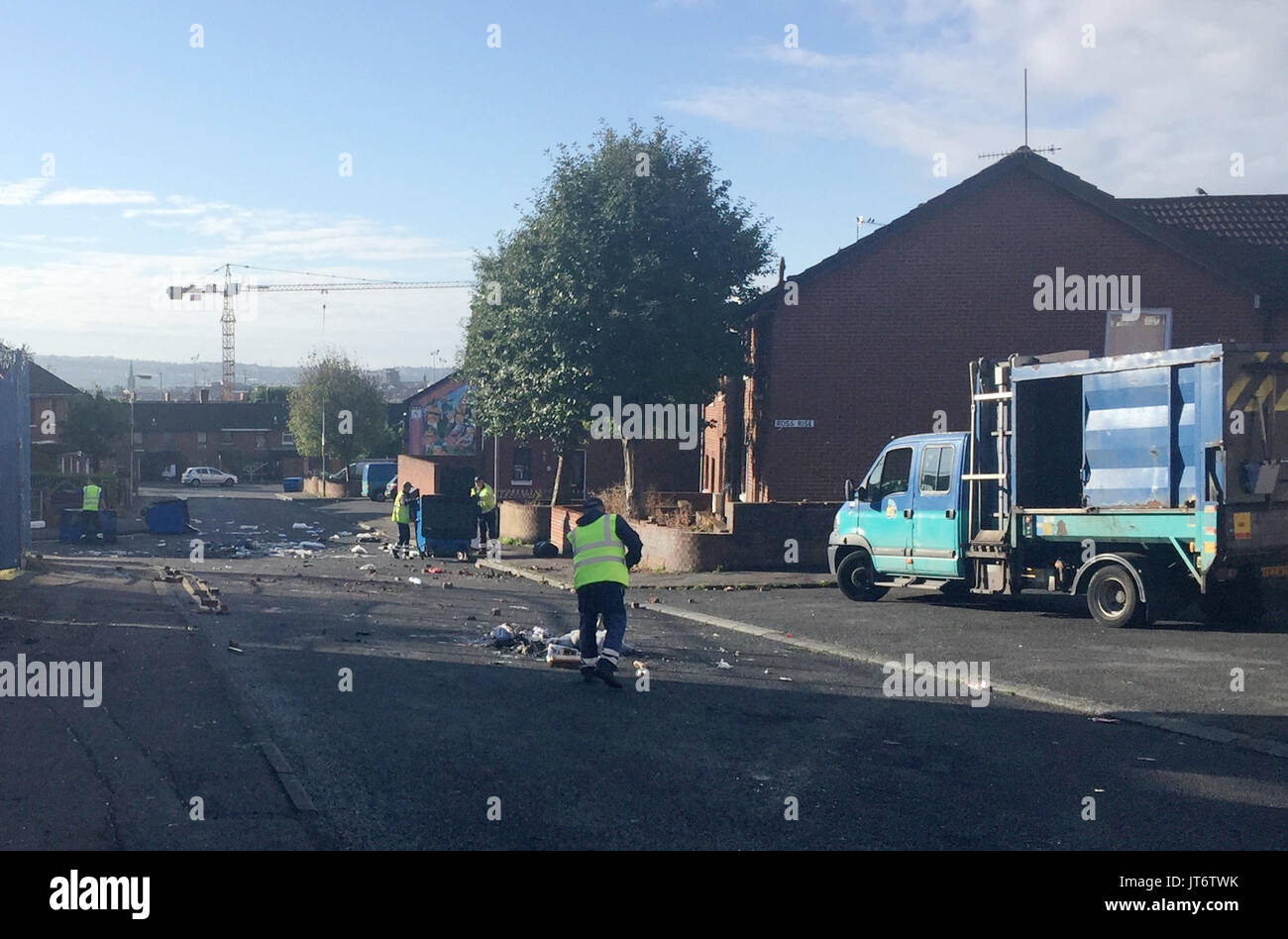 Pulizia inizia nei mercati zona di Belfast, dove la polizia sono stati aggrediti e auto incendiate da giovani mascherati apparentemente adirato per la rimozione del legno dal sito di un nazionalista falò in Belfast. Foto Stock
