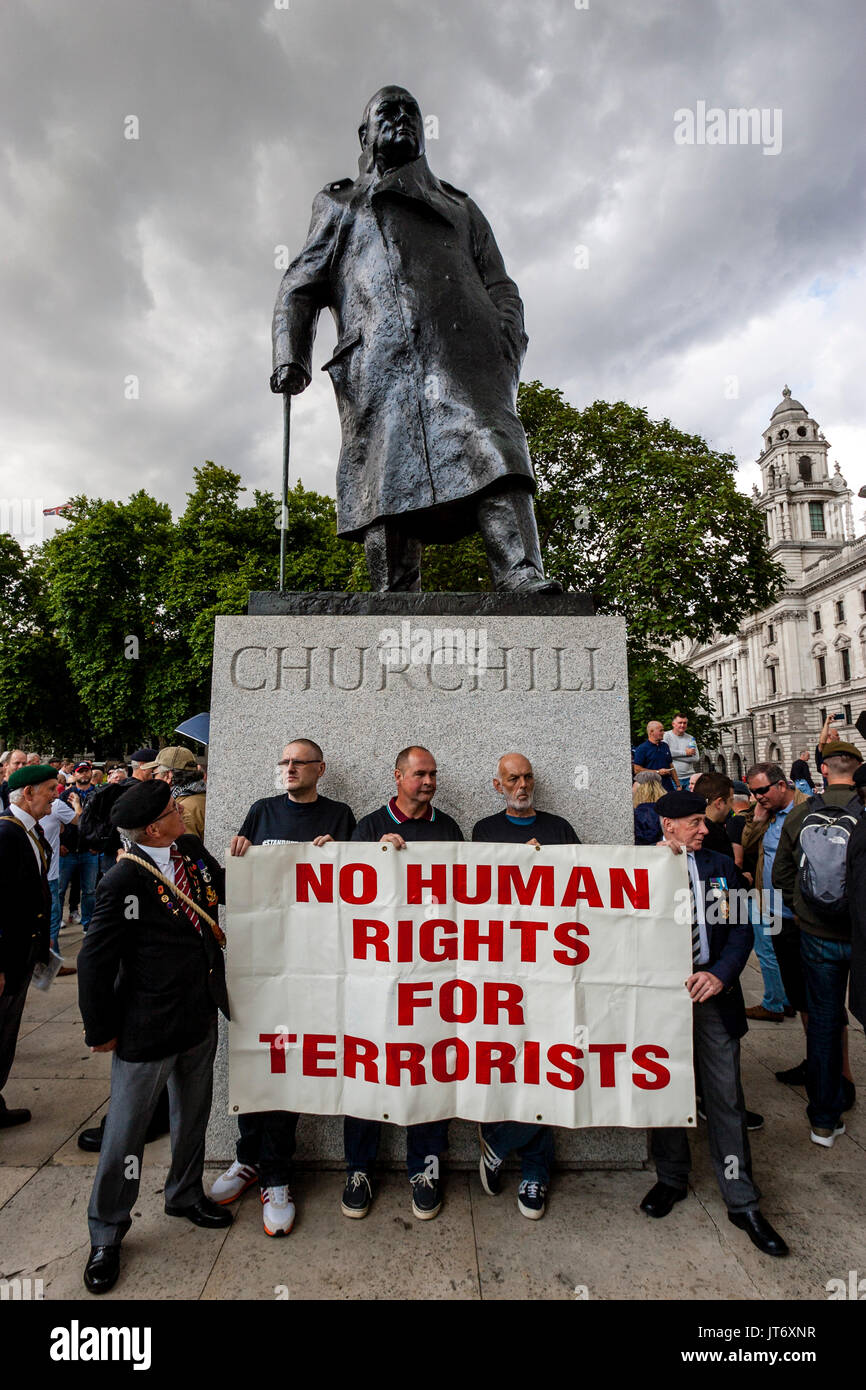 Esercito britannico veterani Stand sotto la statua di Winston Churchill tenendo un Banner chiede 'No i diritti umani di terroristi", London, Regno Unito Foto Stock