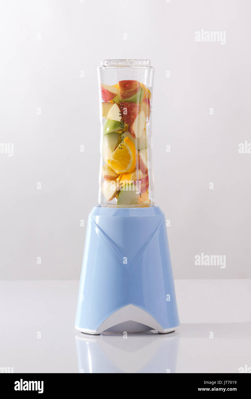 Frutto elettrico frullatore con frutta all'interno isolato su sfondo bianco Foto Stock