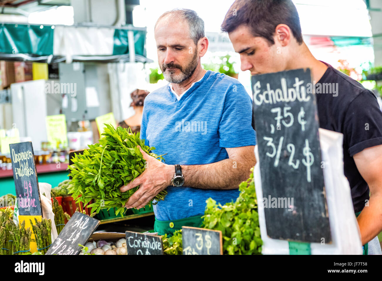 Montreal, Canada - 28 Maggio 2017: Padre e figlio la vendita di produrre da verdura a Jean-Talon farmers market con display Foto Stock