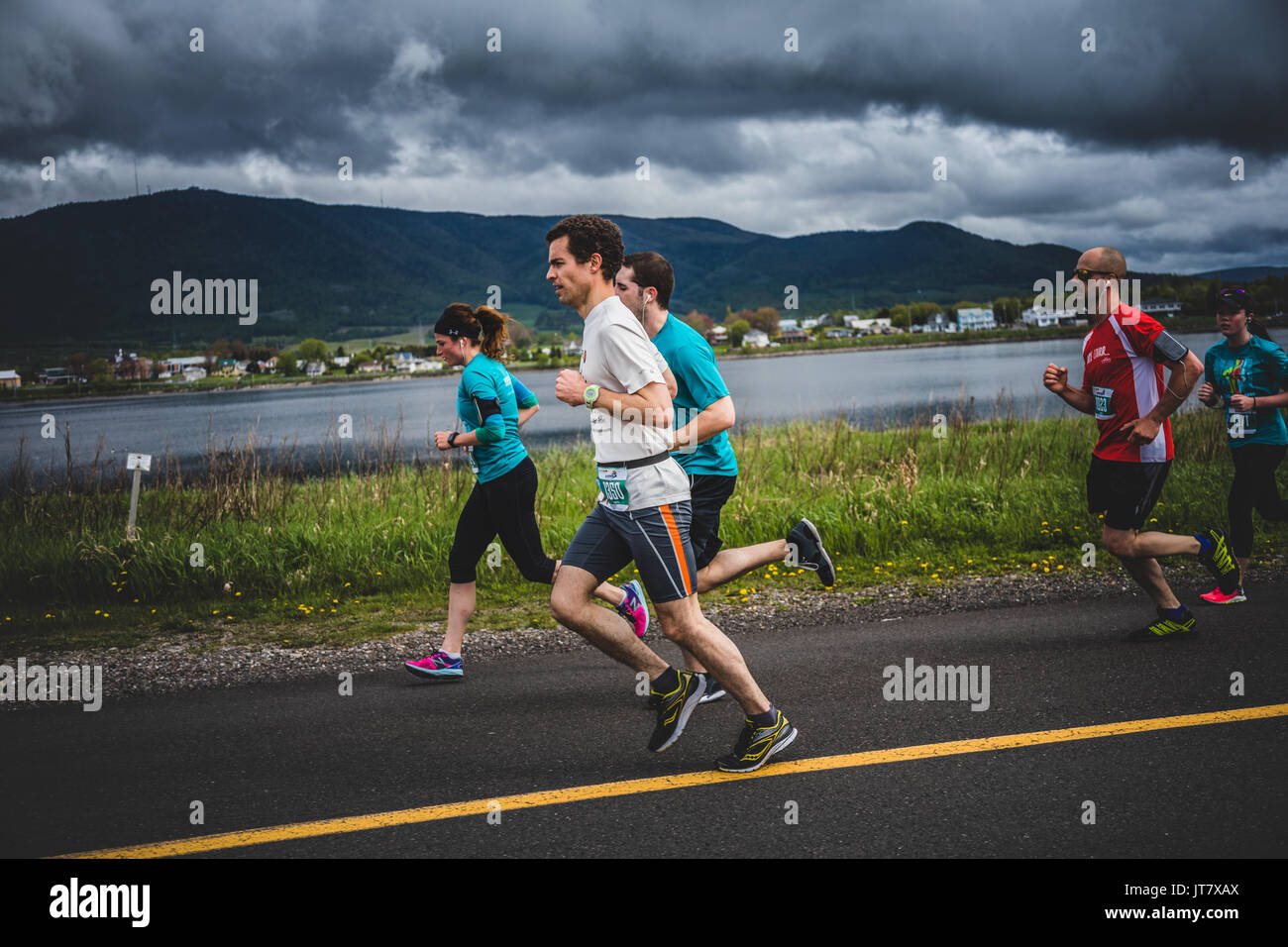 CARLETON, Canada - 4 giugno 2017. Durante la quinta maratona di Carleton in Quebec, Canada. Gruppo di 10K corridori di fronte ad una bella montagna Landscap Foto Stock