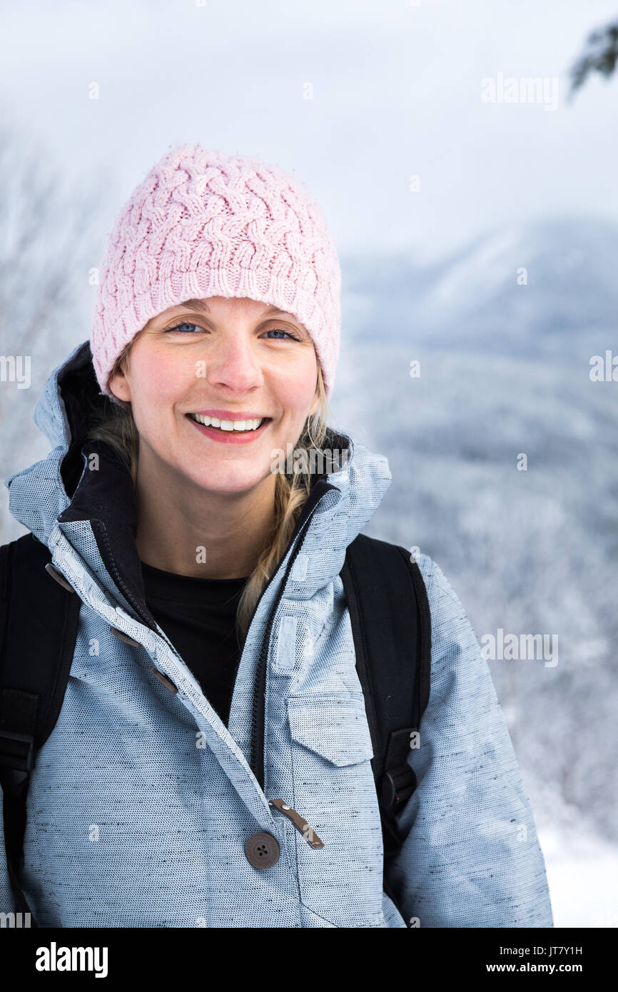 Giovane donna felice ritratto sulla cima di una montagna in inverno Foto Stock