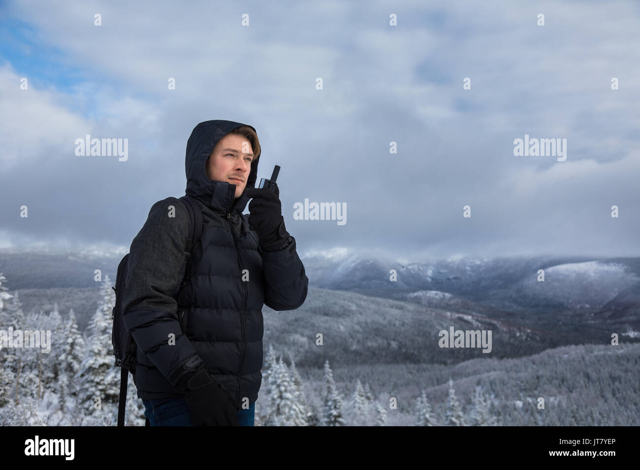 Giovane uomo solo sulla cima della montagna durante il periodo invernale Foto Stock