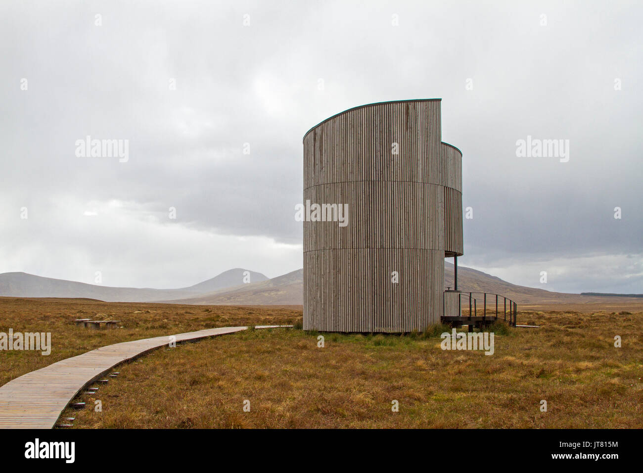 Paesaggio di highland torba paludi dominato dall'architettura unica di uccello circolare nascondere sotto il cielo di pioggia a flussi Forsinard RSPB sito in Scozia Foto Stock