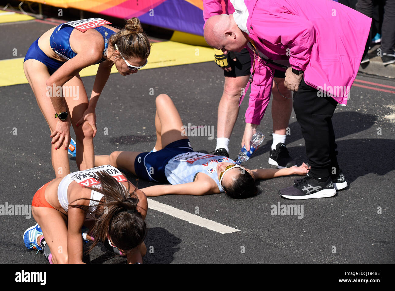 Seongeun Kim, Katarzyna Kowalska è crollata al termine della gara di maratona dei Campionati del mondo IAAF 2017 a Londra, Regno Unito. Con Lindsay Flanagan Foto Stock