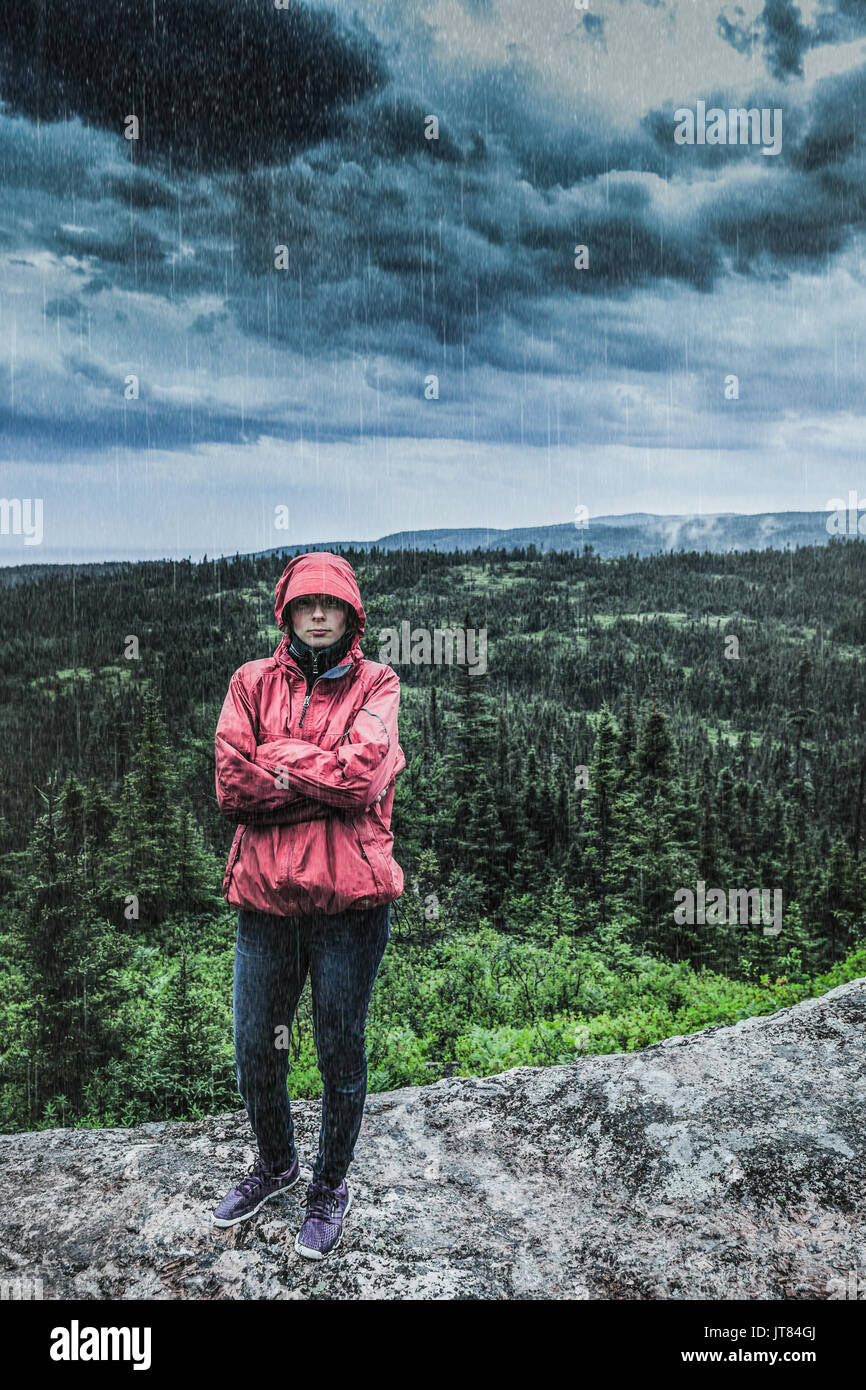 Imprevedibile Heavy Rain versando su un triste e frustrato giovane donna da solo sulla cima di una montagna. Foto Stock