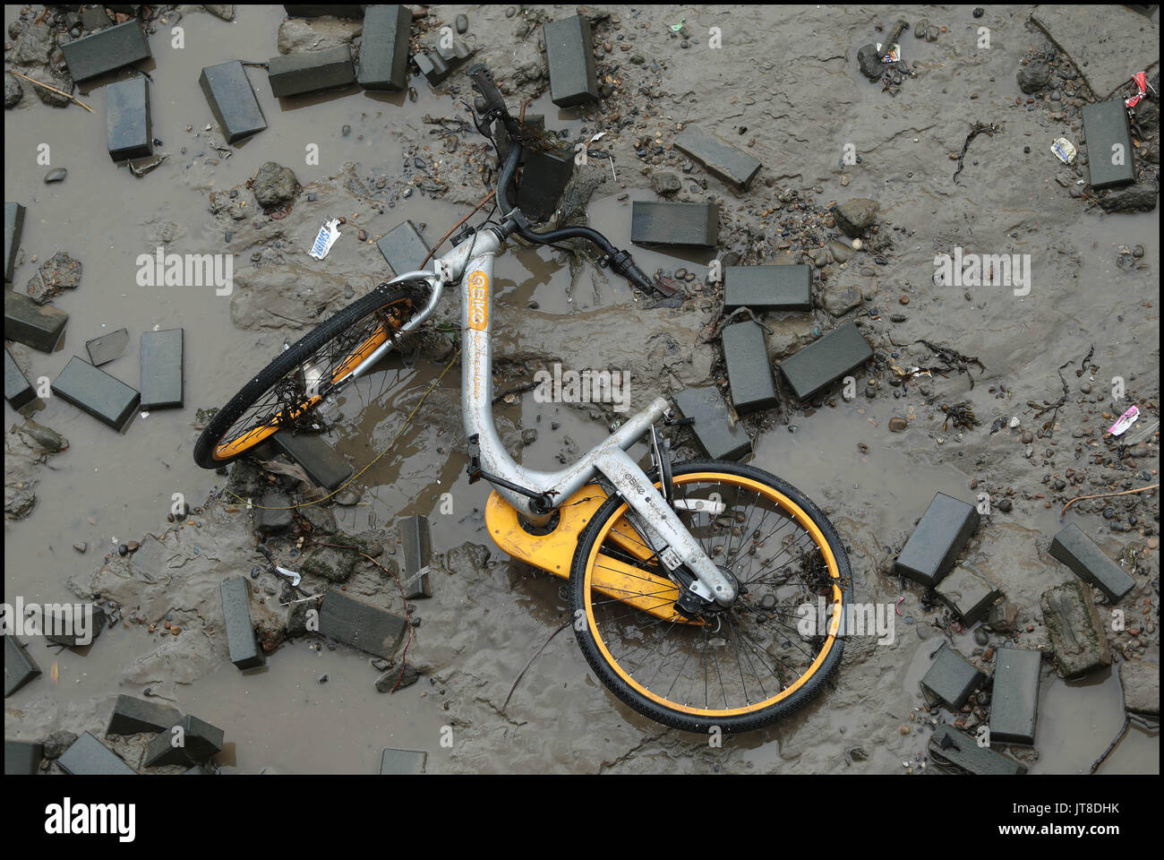 Lndon, UK. Il 7 agosto, 2017. Un marchio nuovo grigio e giallo luminoso o moto trovato gettato nel fiume Tamigi in corrispondenza della bocca del forno per calce Dock vicino a Canary Wharf. La nuova bicicletta schema di noleggio al rivale Boris Bikes ha recentemente lanciato a Londra all'insaputa dei consigli locali. I dirompenti start-up ditta da Singapore è diventato il primo 'dockless' noleggio biciclette nella capitale Credito: Nigel Bowles/Alamy Live News Foto Stock