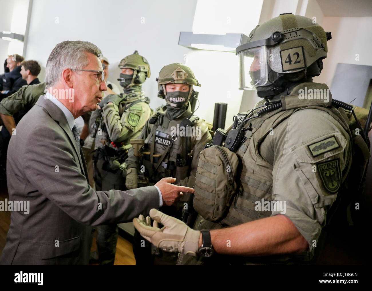 Berlino, Germania. 8 Ago, 2017. dpatop - ministro tedesco degli interni Thomas de Maiziere (CDU) in colloquio con i membri di una nuova élite unità di polizia a Berlino, Germania, 8 agosto 2017. Il gruppo è stato istituito per gestire estremamente complesse operazioni come l'anti-operazioni di terrore. Il gruppo comprende i membri di un certo numero di differenti elite tactical unità compreso il Grenzschutzgruppe 9 (GSG 9; inglese: la protezione alle frontiere Gruppo 9). Foto: Kay Nietfeld/dpa/Alamy Live News Foto Stock