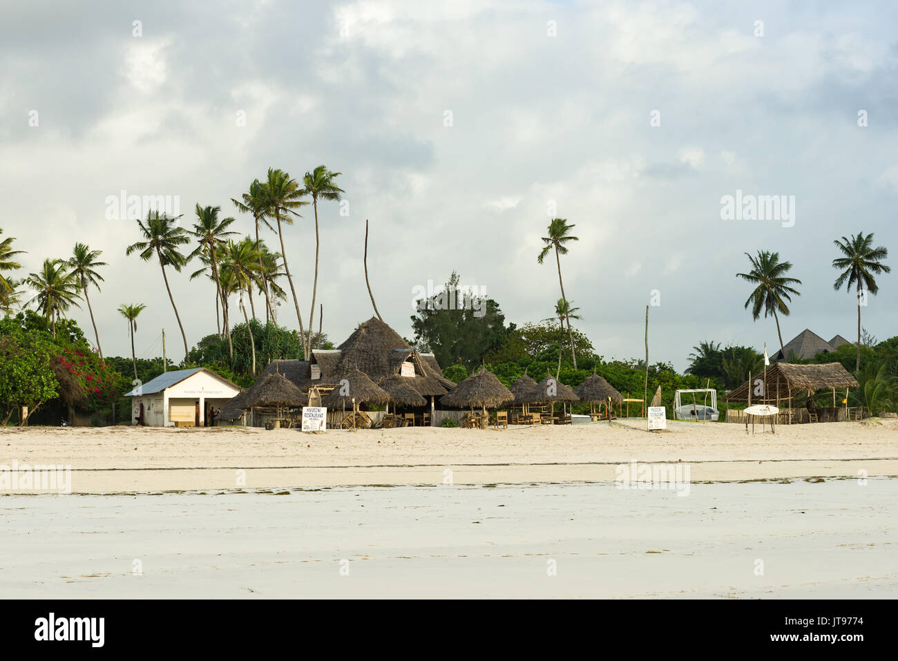 Spiaggia locale ristorante con palme in background in mattina presto luce, Diani Kenya Foto Stock