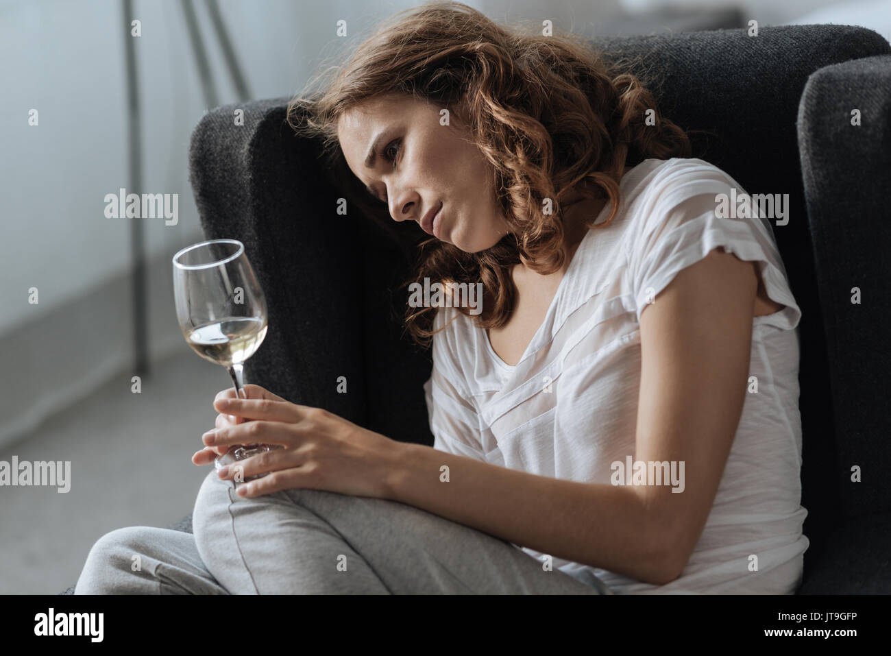 Cupa premuto donna seduta in poltrona Foto Stock