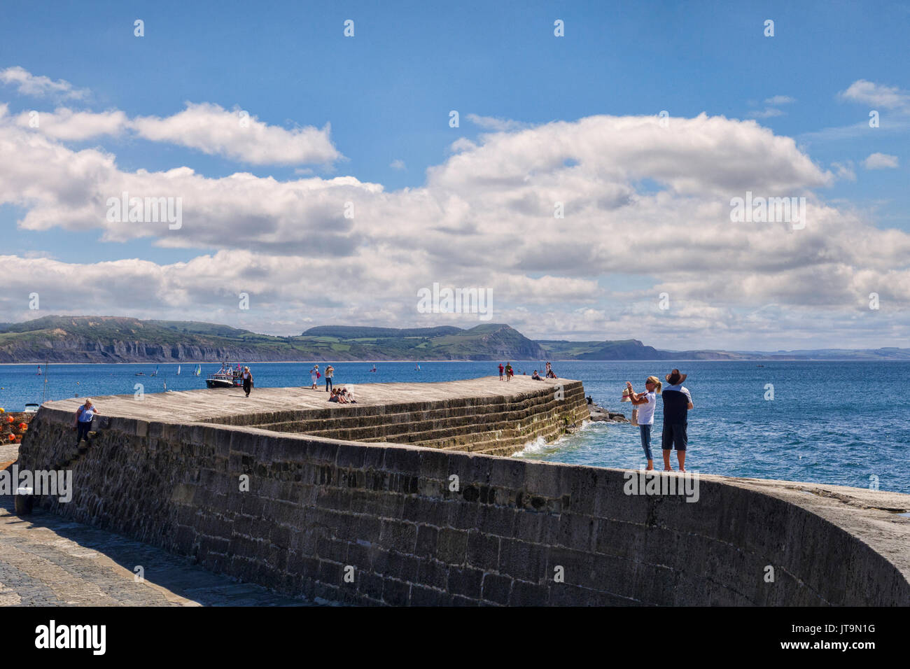 1 Luglio 2017: Lyme Regis, Dorset, England, Regno Unito - Visitatori passeggiando sul Cobb su una bella e soleggiata giornata d'estate. Foto Stock