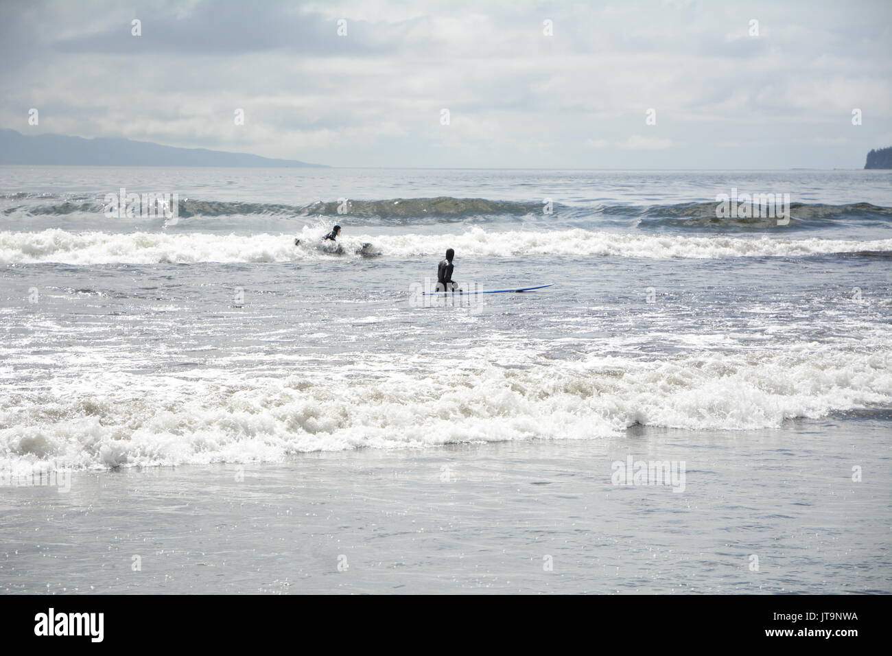 Una coppia di surfisti sulla spiaggia Pacheedaht, su una riserva nativa dello stesso nome, vicino a Port Renfrew, Isola di Vancouver, British Columbia, Canada. Foto Stock