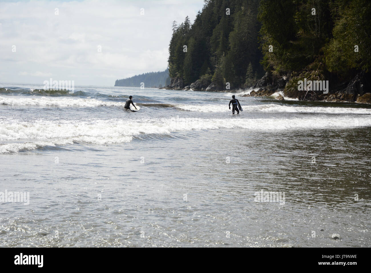 Una coppia di surfisti sulla spiaggia Pacheedaht, su una riserva nativa dello stesso nome, vicino a Port Renfrew, Isola di Vancouver, British Columbia, Canada. Foto Stock