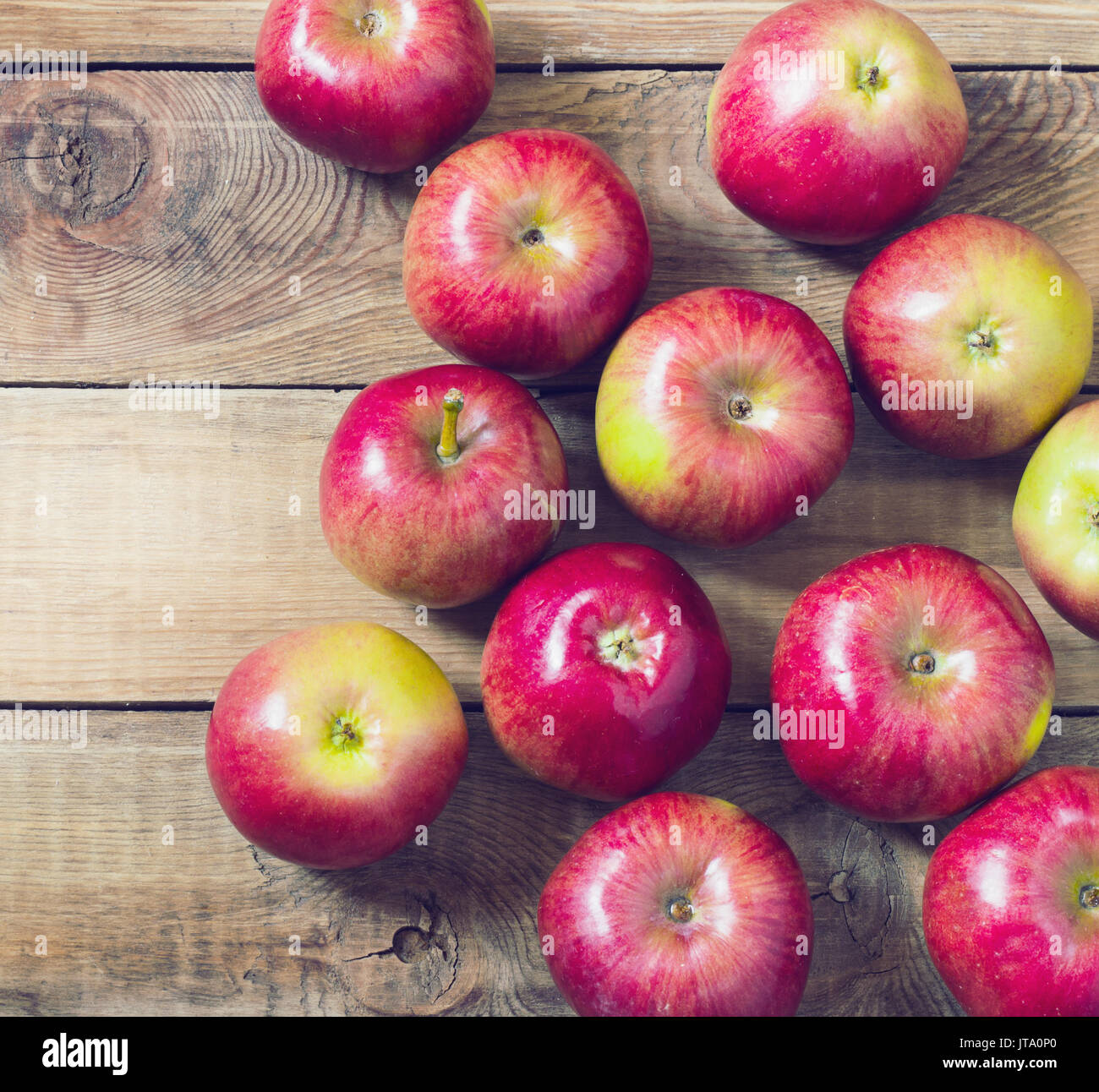 Una bella mele rosse su uno sfondo di legno tonificante Foto Stock