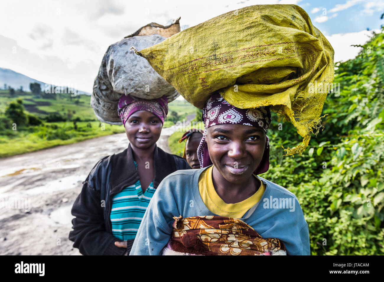 Donne locali che effettuano il trasporto di merci sulle loro teste, il Parco nazionale di Virunga, Repubblica Democratica del Congo, Africa Foto Stock