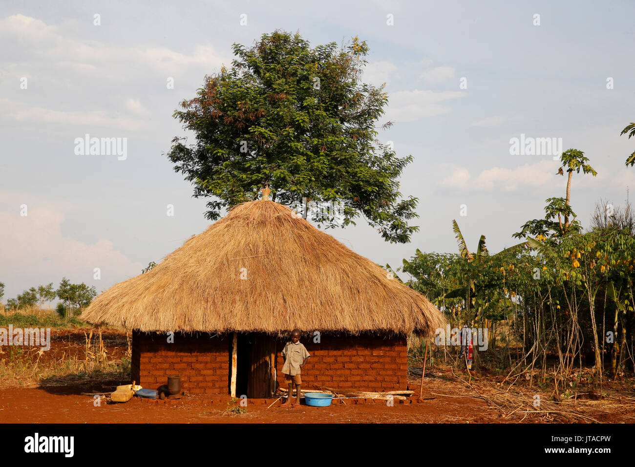 Bambino ugandese al di fuori di casa sua, Bweyale, Uganda, Africa Foto Stock