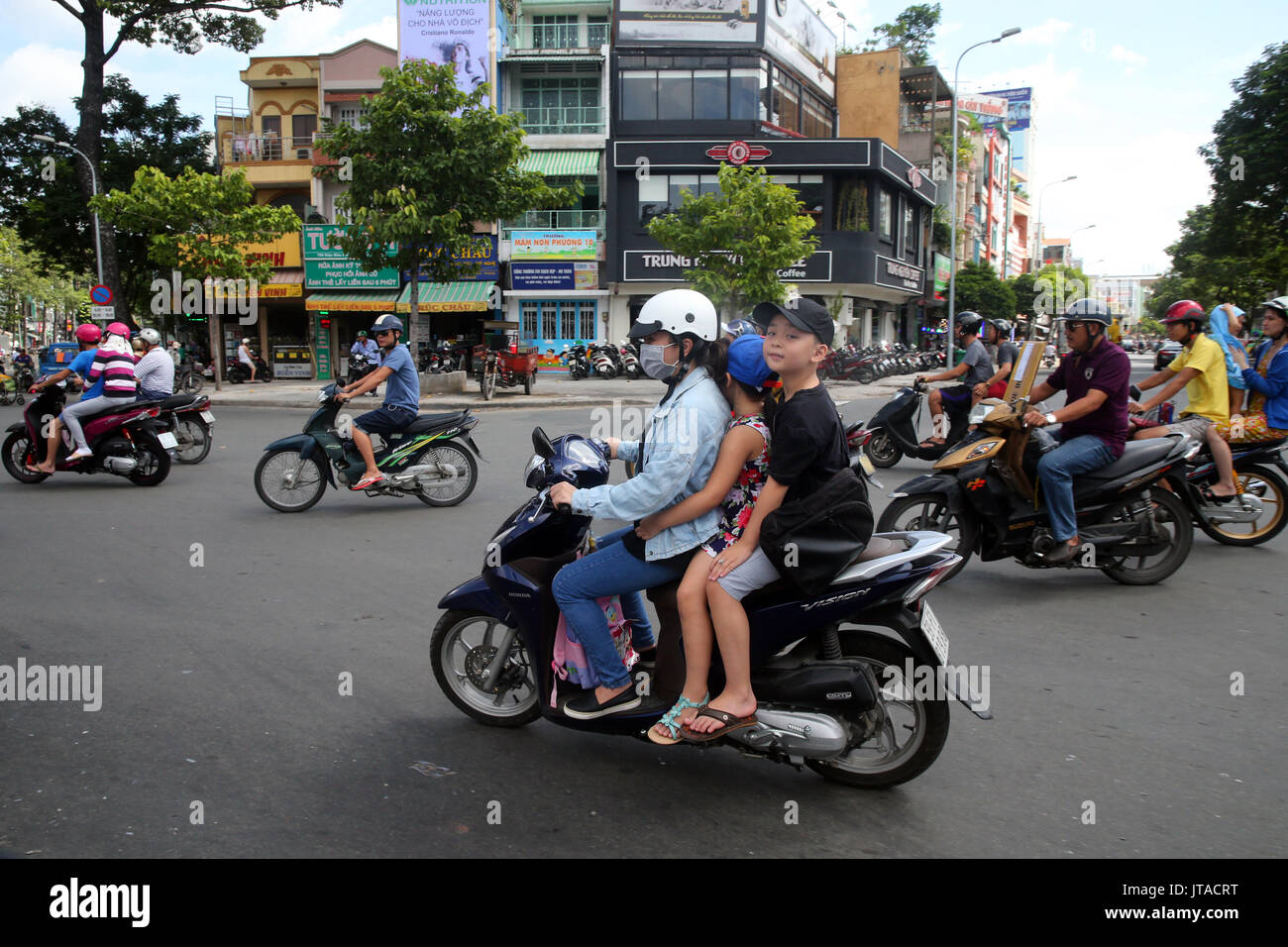 Madre e bambini su scooter a Saigon Street, Città di Ho Chi Minh, Vietnam, Indocina, Asia sud-orientale, Asia Foto Stock