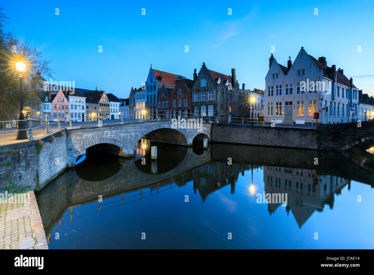 Le luci del tramonto su edifici storici del centro città si riflette nei tipici canali di Bruges, Fiandre Occidentali, Belgio, Europa Foto Stock