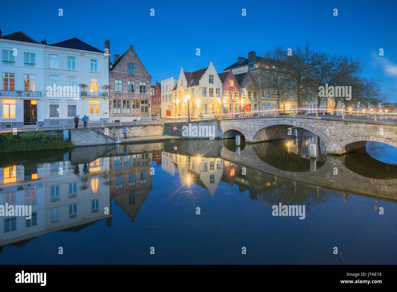 Le luci del tramonto su edifici storici del centro città si riflette nei tipici canali di Bruges, Fiandre Occidentali, Belgio, Europa Foto Stock