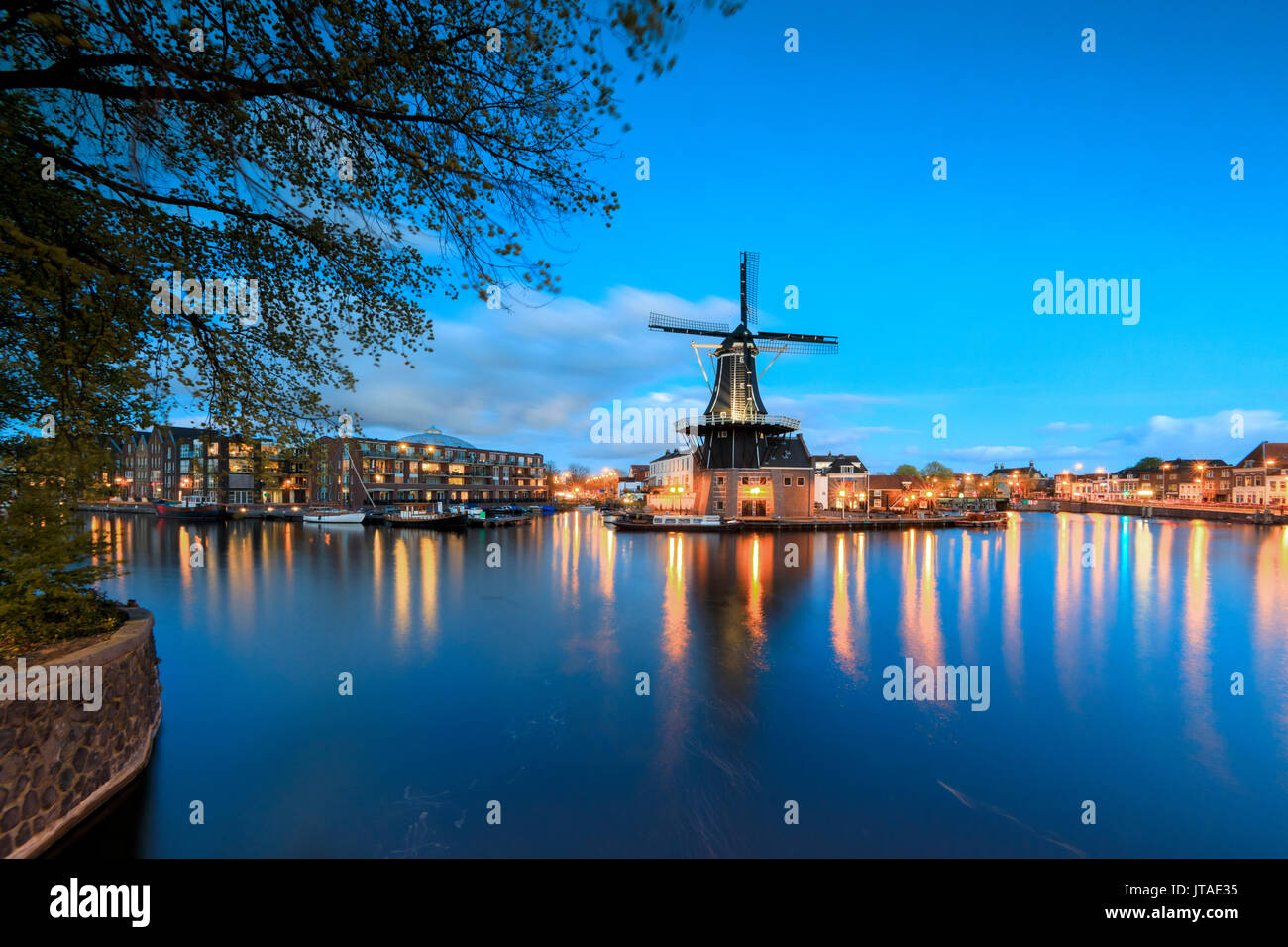 Le luci del tramonto sul mulino a vento De Adriaan riflessa nel fiume Spaarne, Haarlem, Olanda Settentrionale, Paesi Bassi, Europa Foto Stock