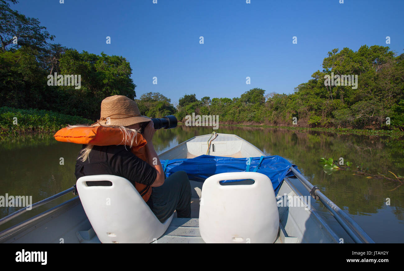 Tourist fotografare la fauna selvatica con una reflex digitale da barca, Pantanal, Brasile. Modello rilasciato Foto Stock