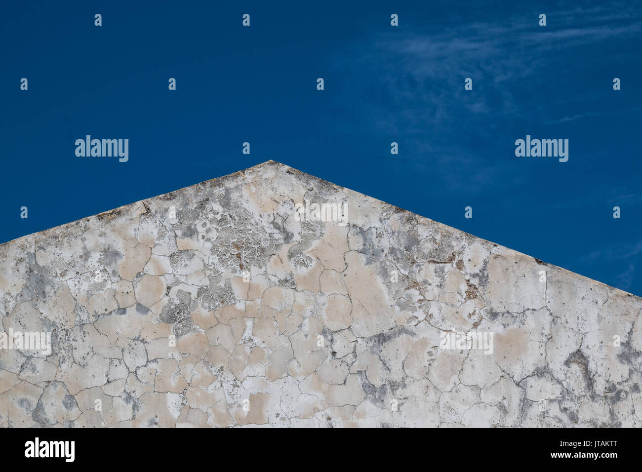 La facciata strutturata di una vecchia casa. Linee del tetto. Littlebit nuvoloso cielo blu. Foto Stock