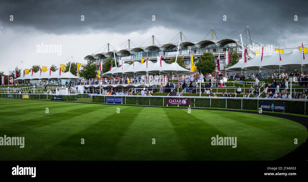 Nuvole temporalesche passano come le persone si radunano intorno al paddock durante la gloriosa Goodwood 2017 nel West Sussex Foto Stock