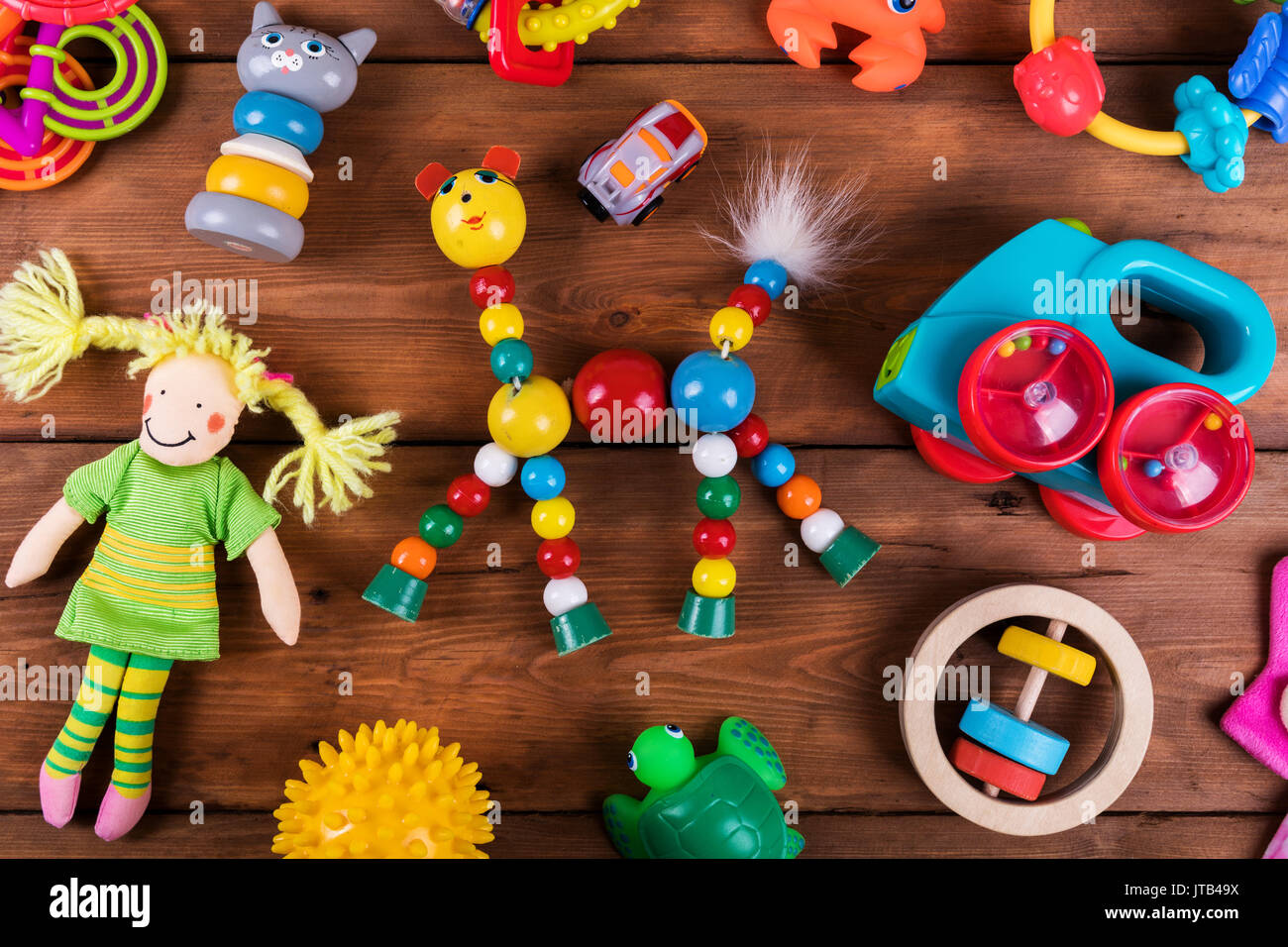 Gruppo di coloratissimi giocattoli per neonati su sfondo di legno. vista superiore Foto Stock