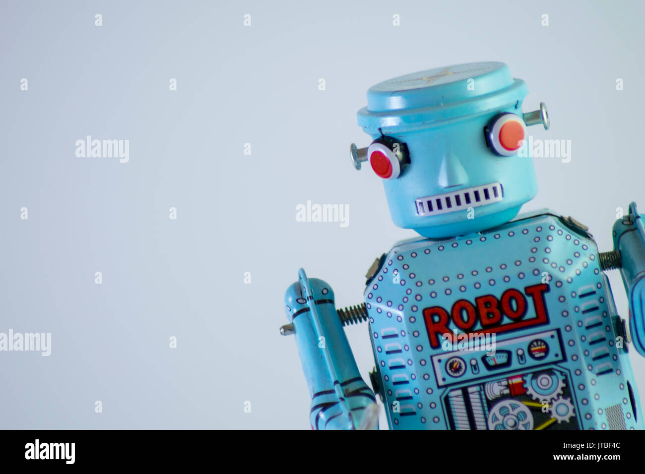 Robot di metallo toy rivolto verso la fotocamera davanti a uno sfondo bianco Foto Stock