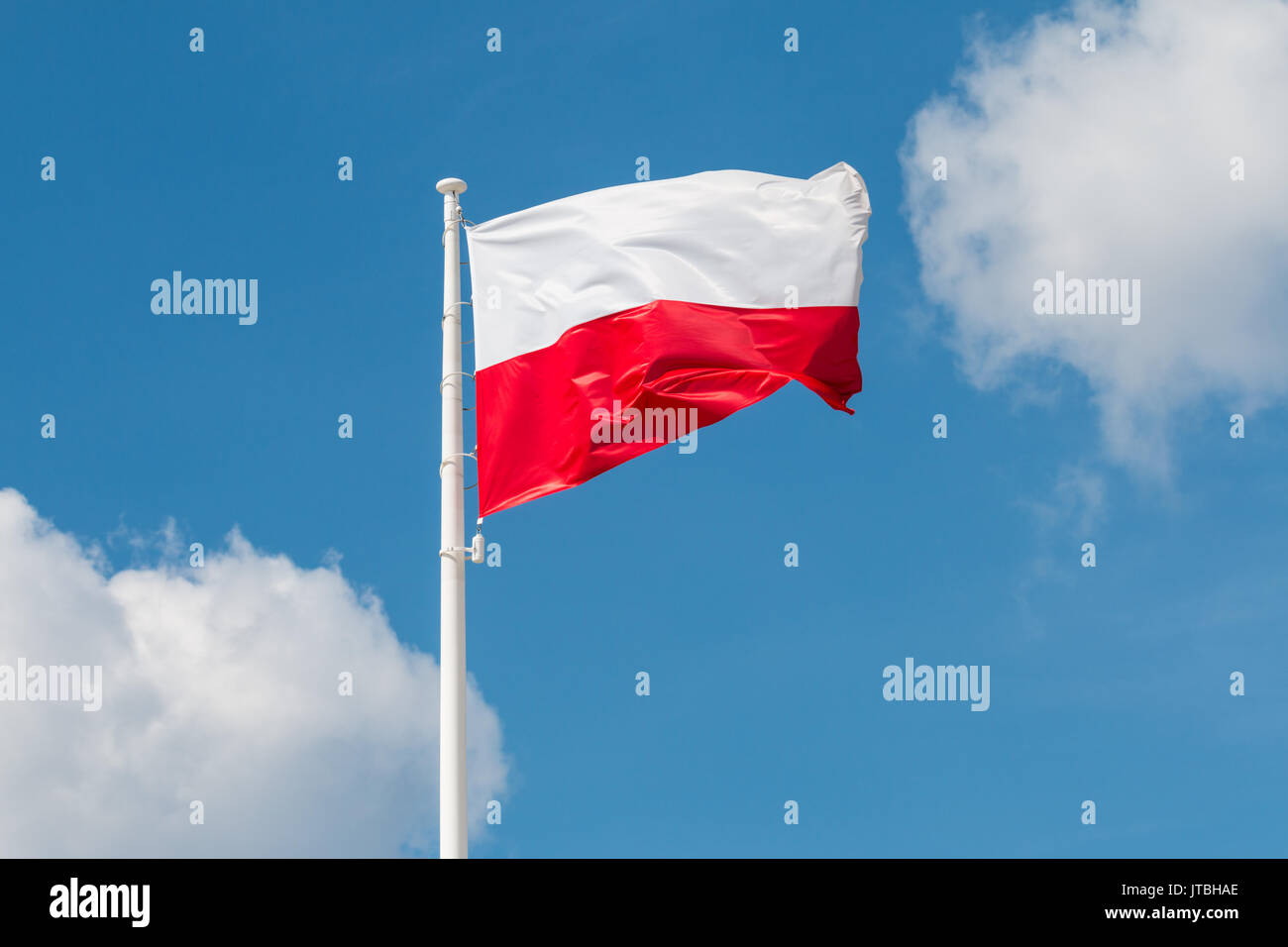 Sventola bandiera nazionale della Polonia su un pennone, colori nazionali della Polonia. Foto Stock
