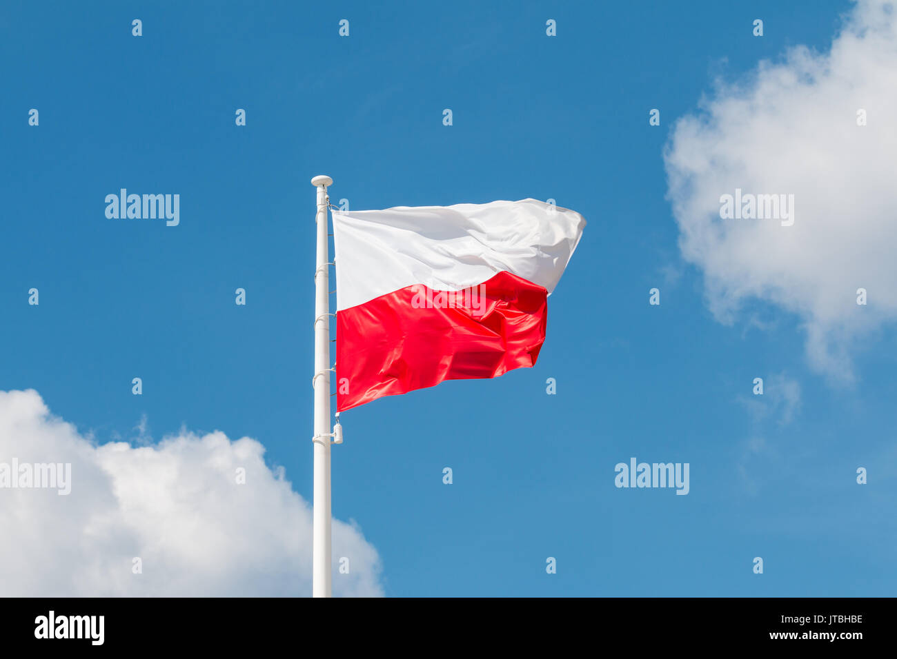 Sventola bandiera nazionale della Polonia su un pennone, colori nazionali della Polonia. Foto Stock