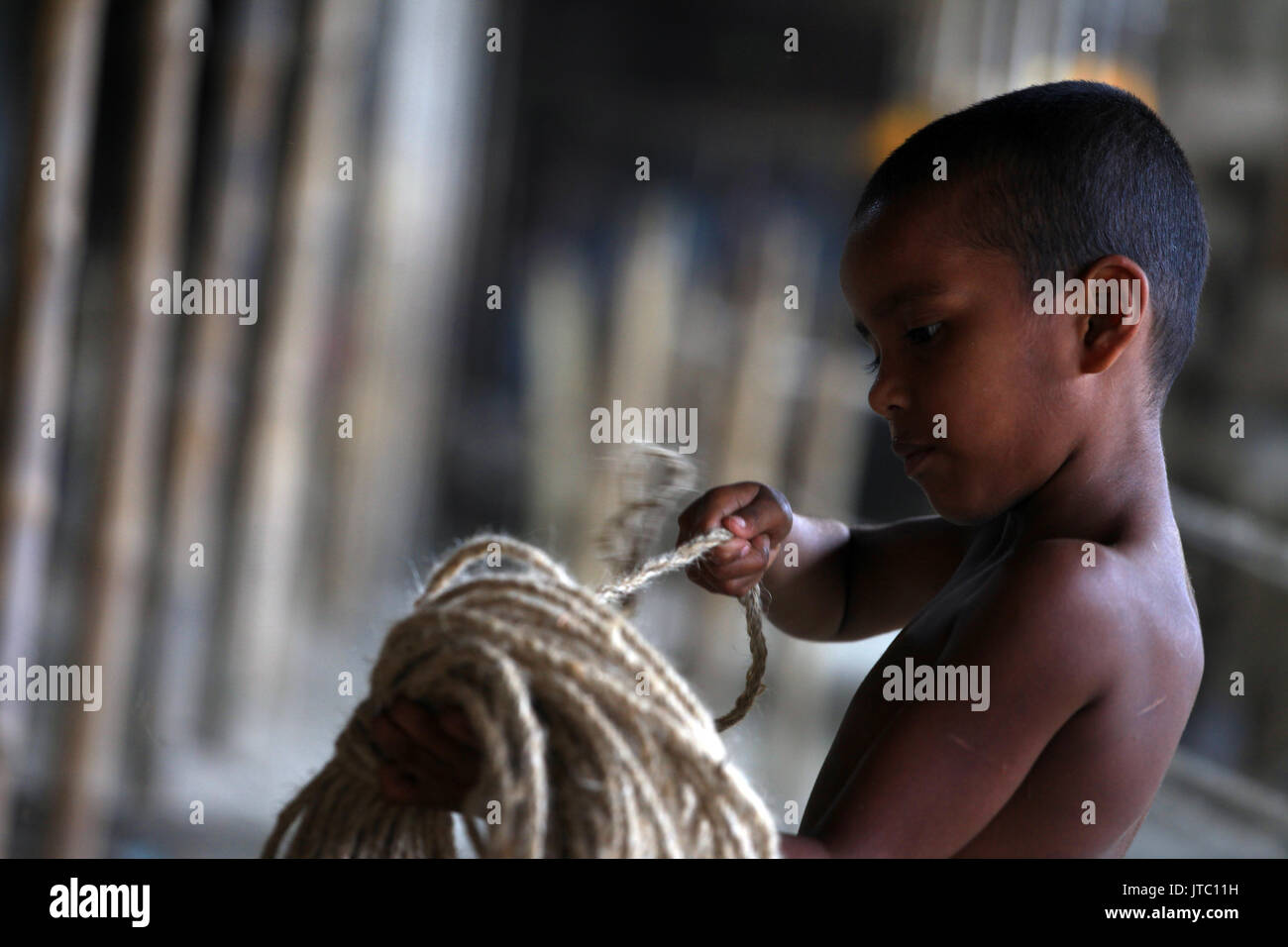 Bambino fatiche lavorando in una corda manufacturing factory a Keraniganj a Dhaka il 29 maggio 2013. Foto Stock