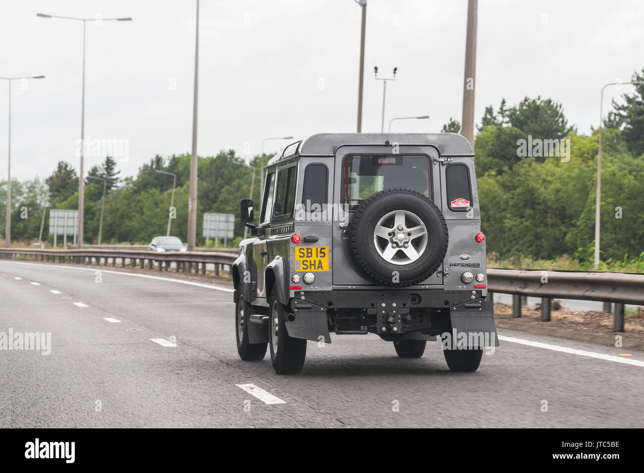 Un Land Rover Defender la guida su una strada principale nel Regno Unito Foto Stock
