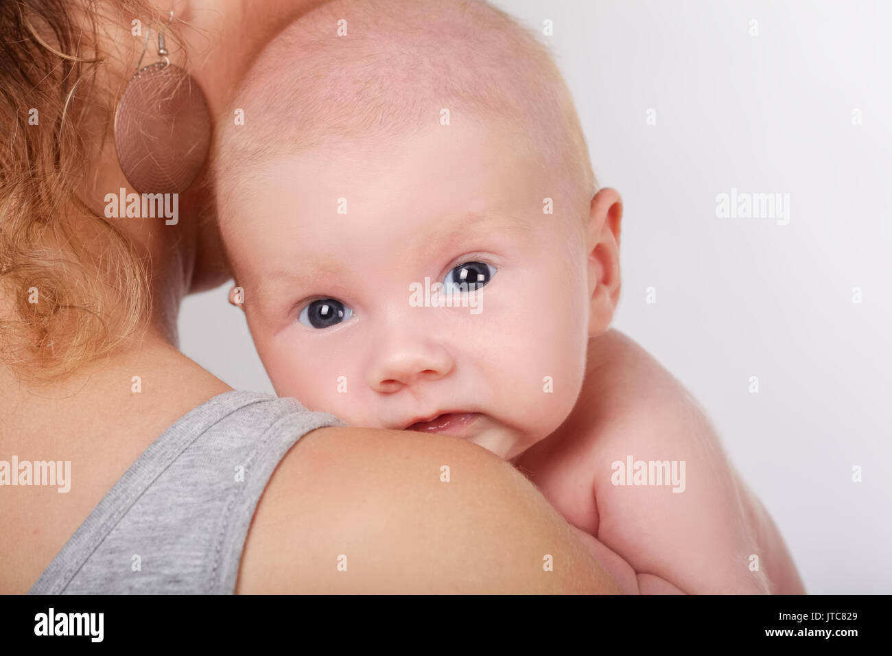 Foto di carino neonato sulle madri spallamento Foto Stock
