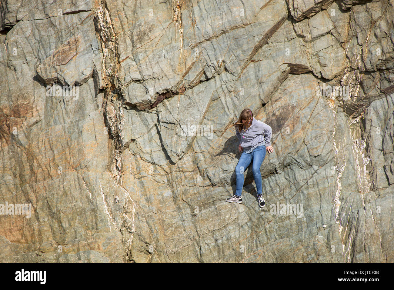 Una giovane ragazza bloccato su una parete di roccia. Foto Stock