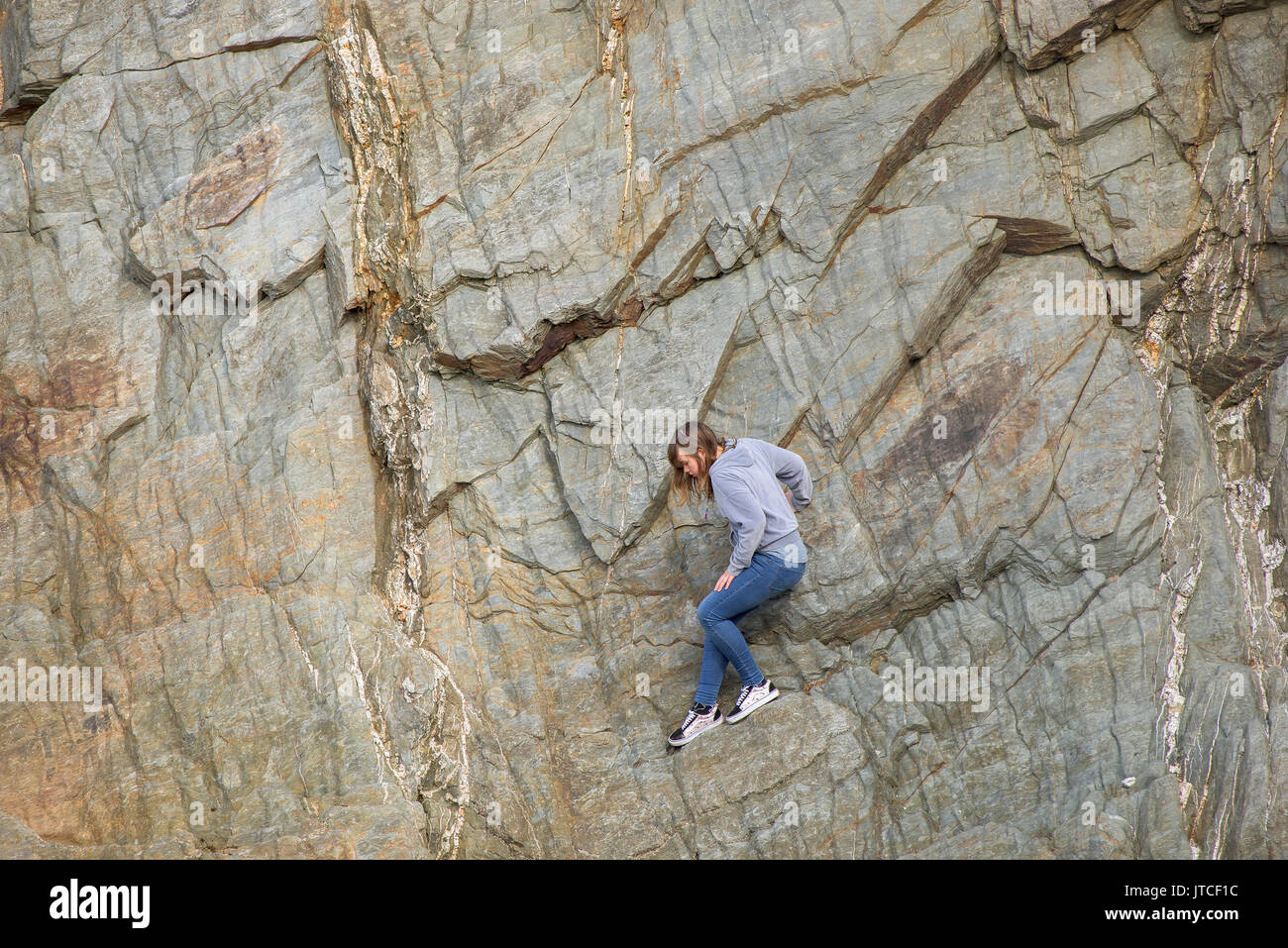 Una giovane ragazza bloccato su una parete di roccia. Foto Stock