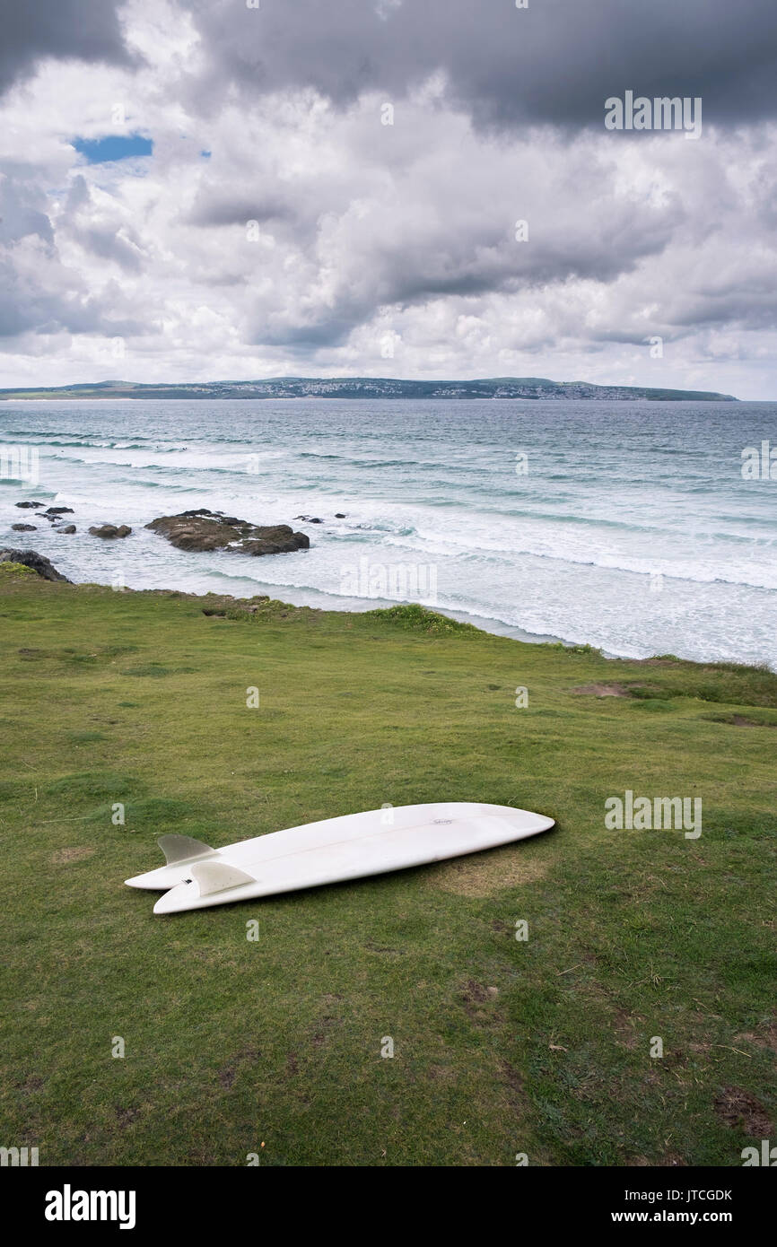 Una tavola da surf a sinistra sulla scogliera che si affaccia su St Ives Bay a Godrevy in Cornovaglia. Foto Stock