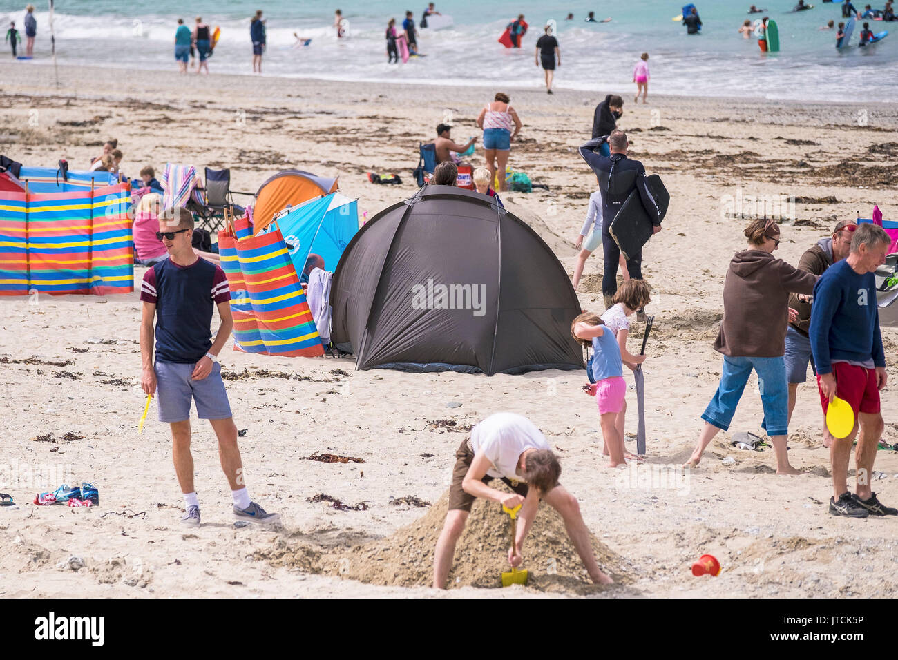 I vacanzieri in vacanza in vacanza godendosi sulla spiaggia a Portreath in Cornovaglia. Foto Stock
