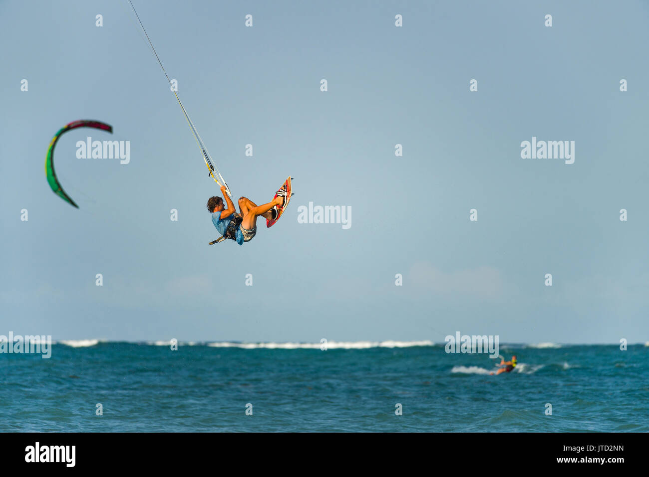 Kite surfer in aria con altri kitesurfer e kite in background in oceano, Diani, Kenya Foto Stock