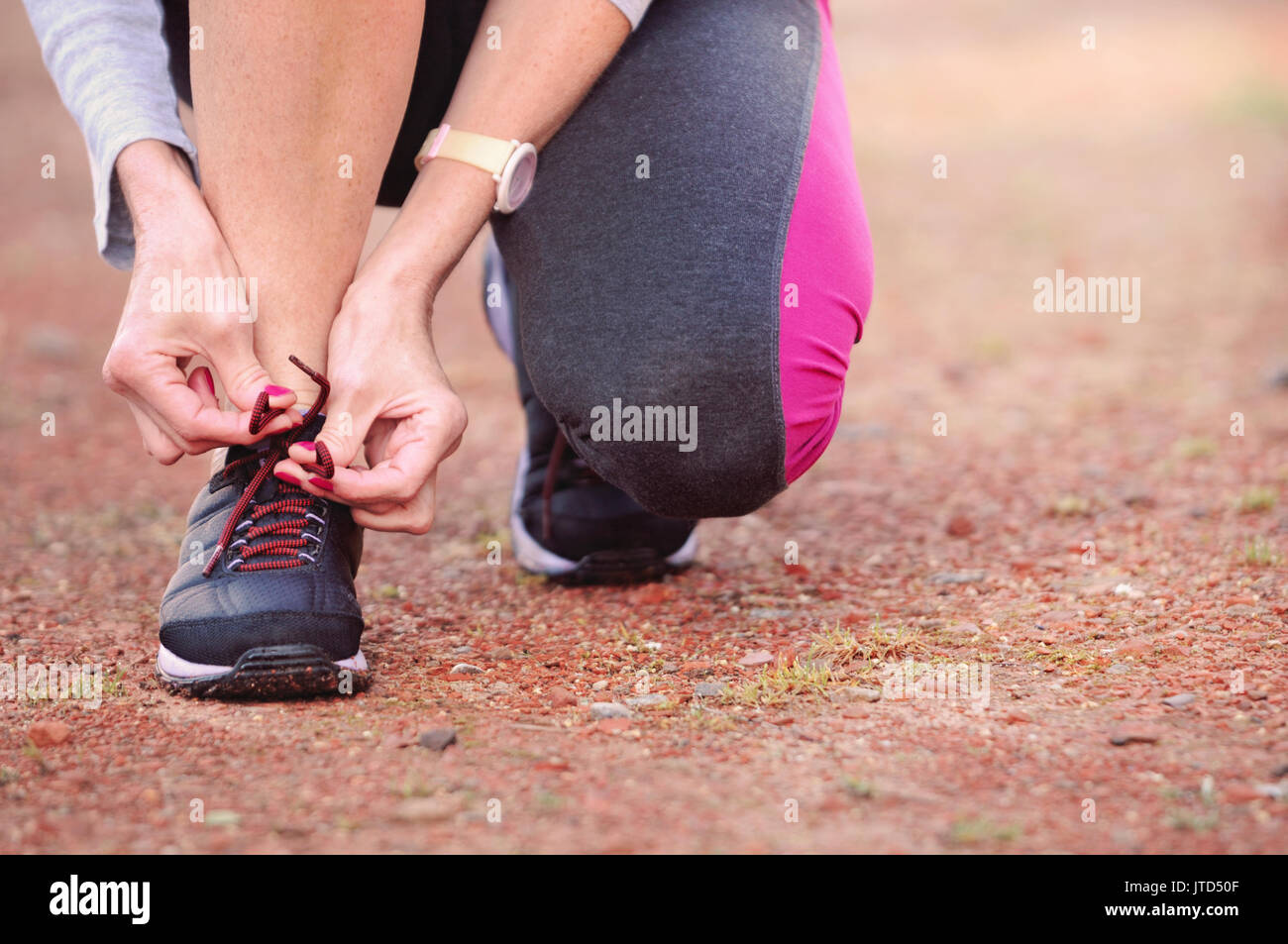 La donna si lega a lacci delle scarpe su sneakers. Vista ravvicinata. Uno stile di vita sano concetto. Foto Stock