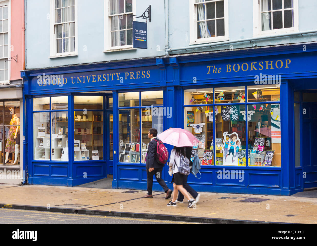 I turisti che camminano oltre l'Oxford University Press Bookshop ad High Street, Oxford, Oxfordshire UK nel mese di agosto in una giornata piovosa bagnata Foto Stock