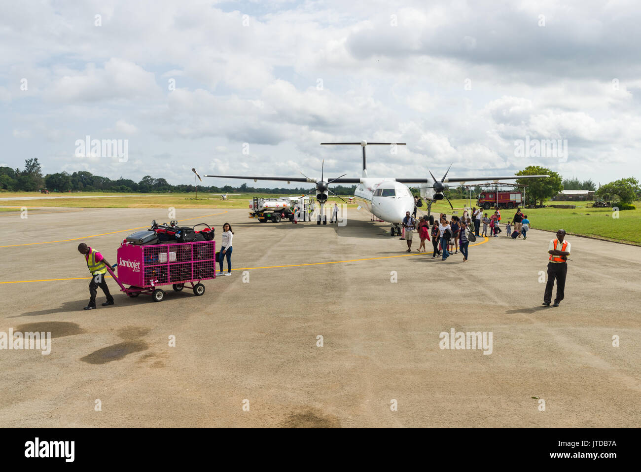 Passeggeri acceso da un Jambojet Bombardier Q400 aeromobile da Nairobi a Ukunda pista di atterraggio per aerei Aeroporto sulla costa Kenyas Foto Stock