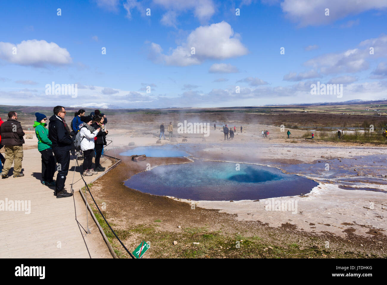 I turisti la visualizzazione di una pentola di fango a Geysir area geotermale, Islanda Foto Stock