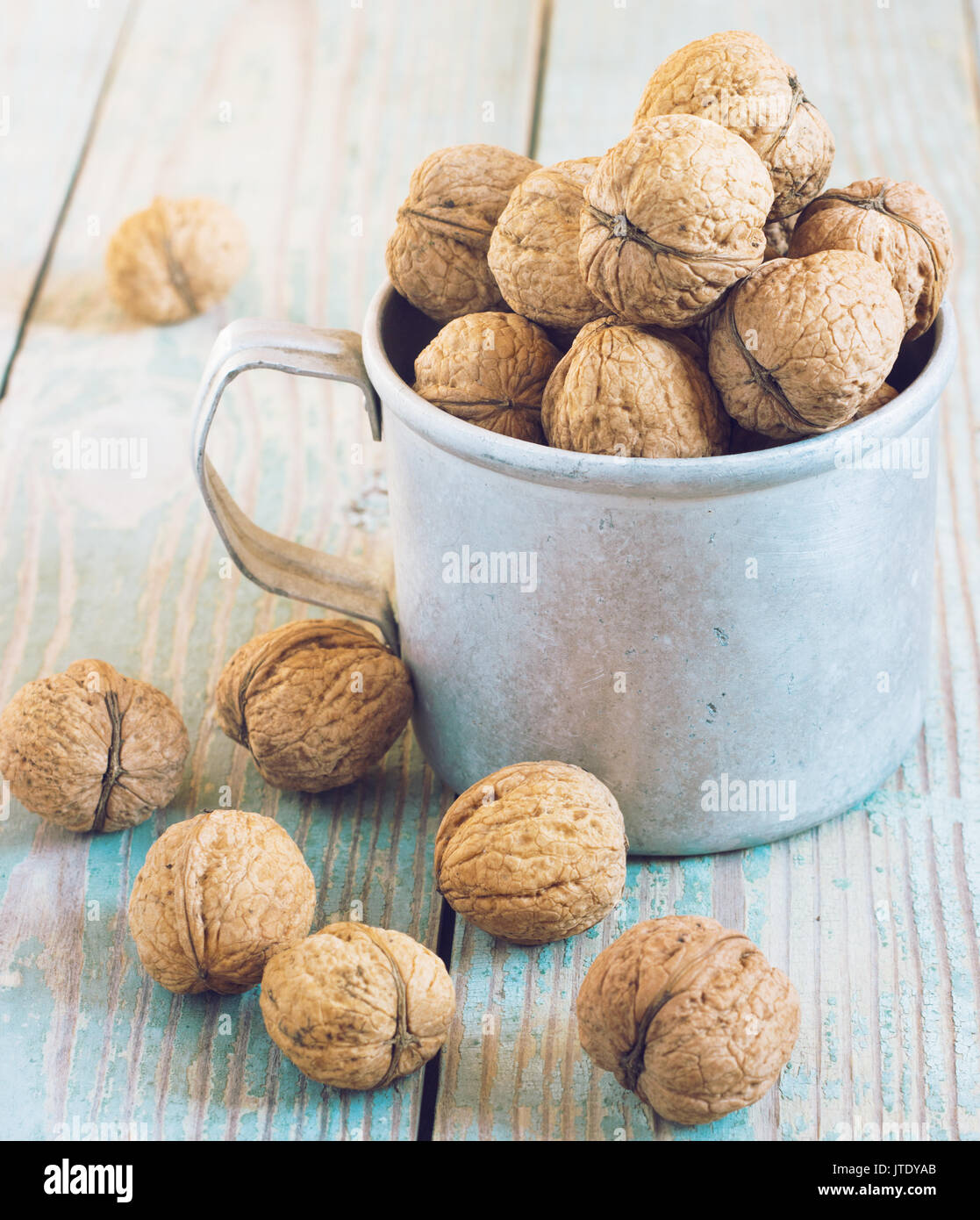 Pila di noci su uno sfondo di legno . Sacco biancheria con noci in background. tonificante Foto Stock