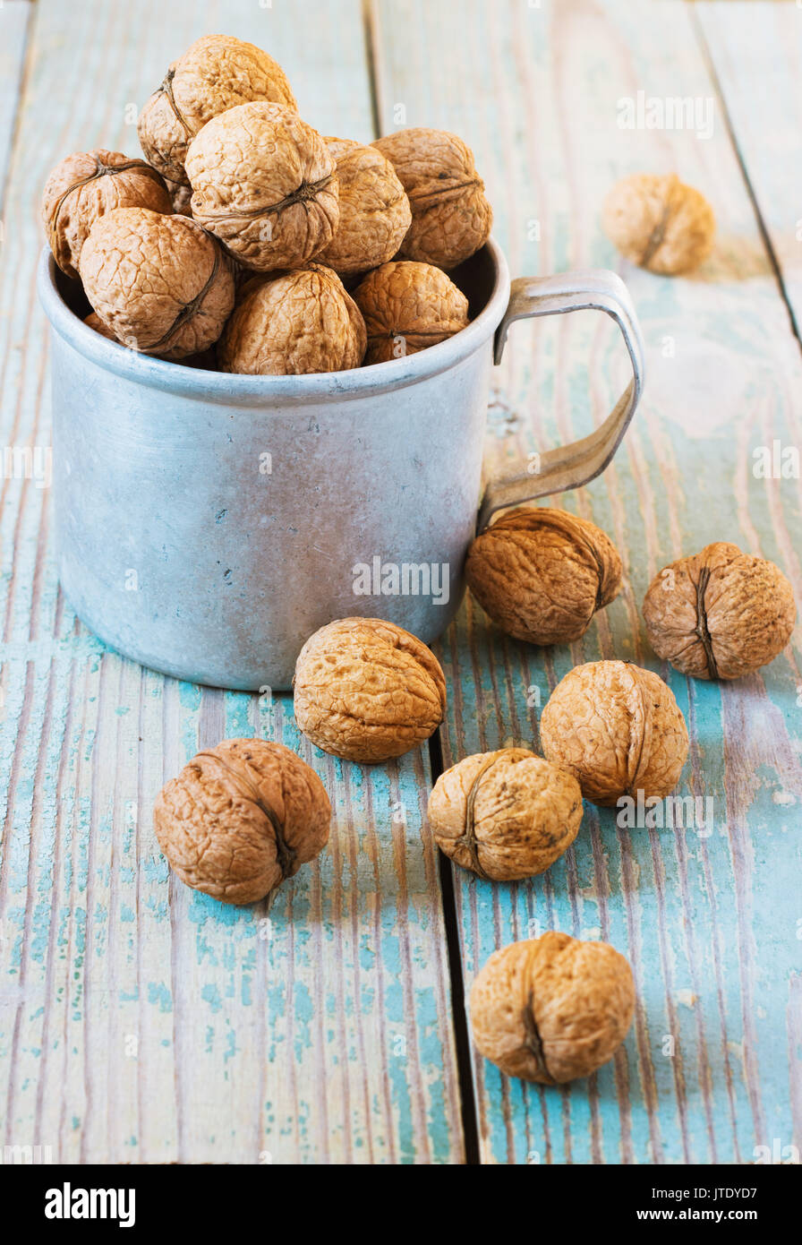 Pila di noci su uno sfondo di legno . Sacco biancheria con noci in background. tonificante Foto Stock