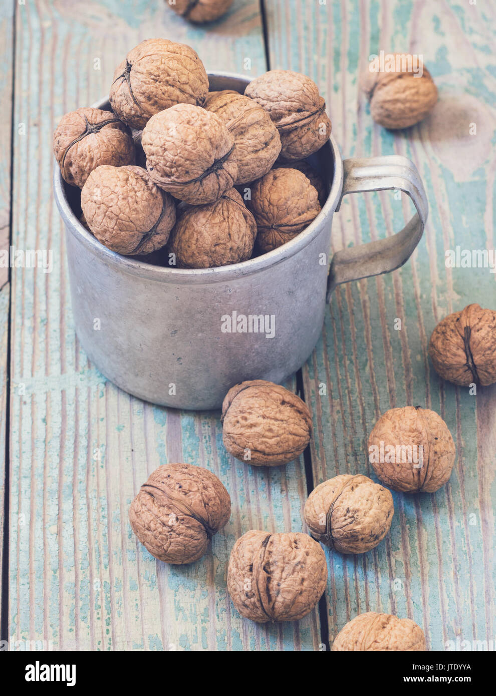 Pila di noci su uno sfondo di legno . Sacco biancheria con noci in background. tonificante Foto Stock