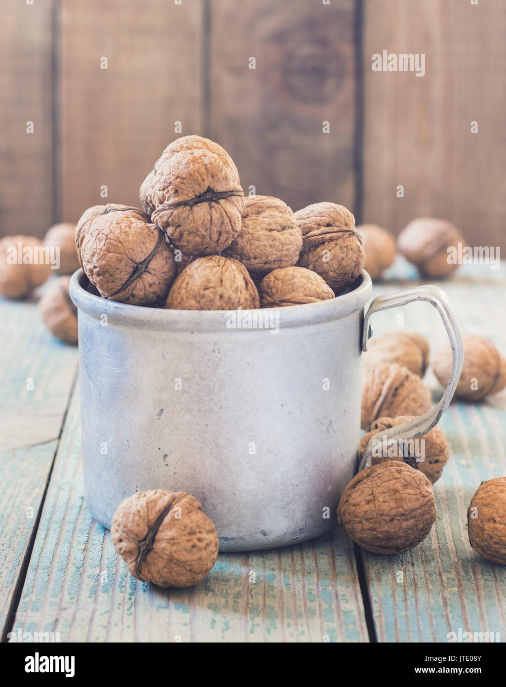 Pila di noci su uno sfondo di legno . Sacco biancheria con noci in background. tonificante Foto Stock